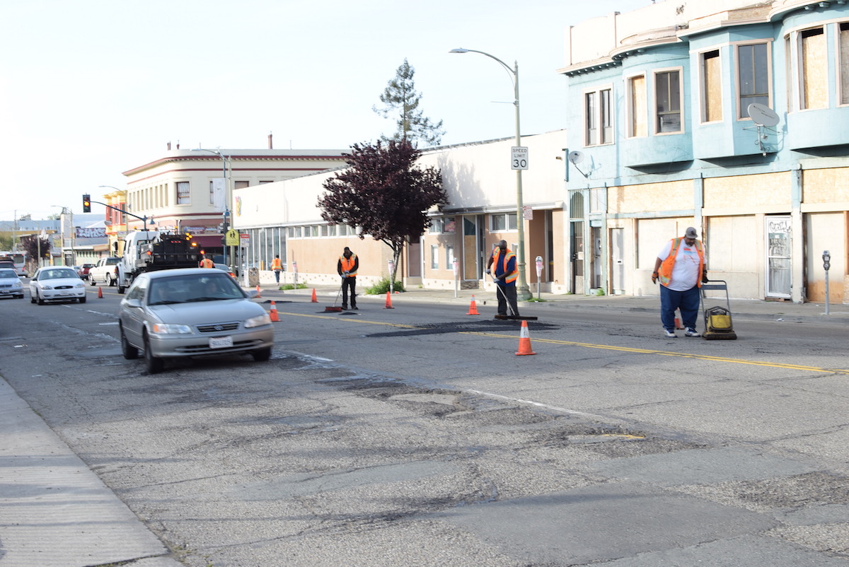 Workers patch holes in the street