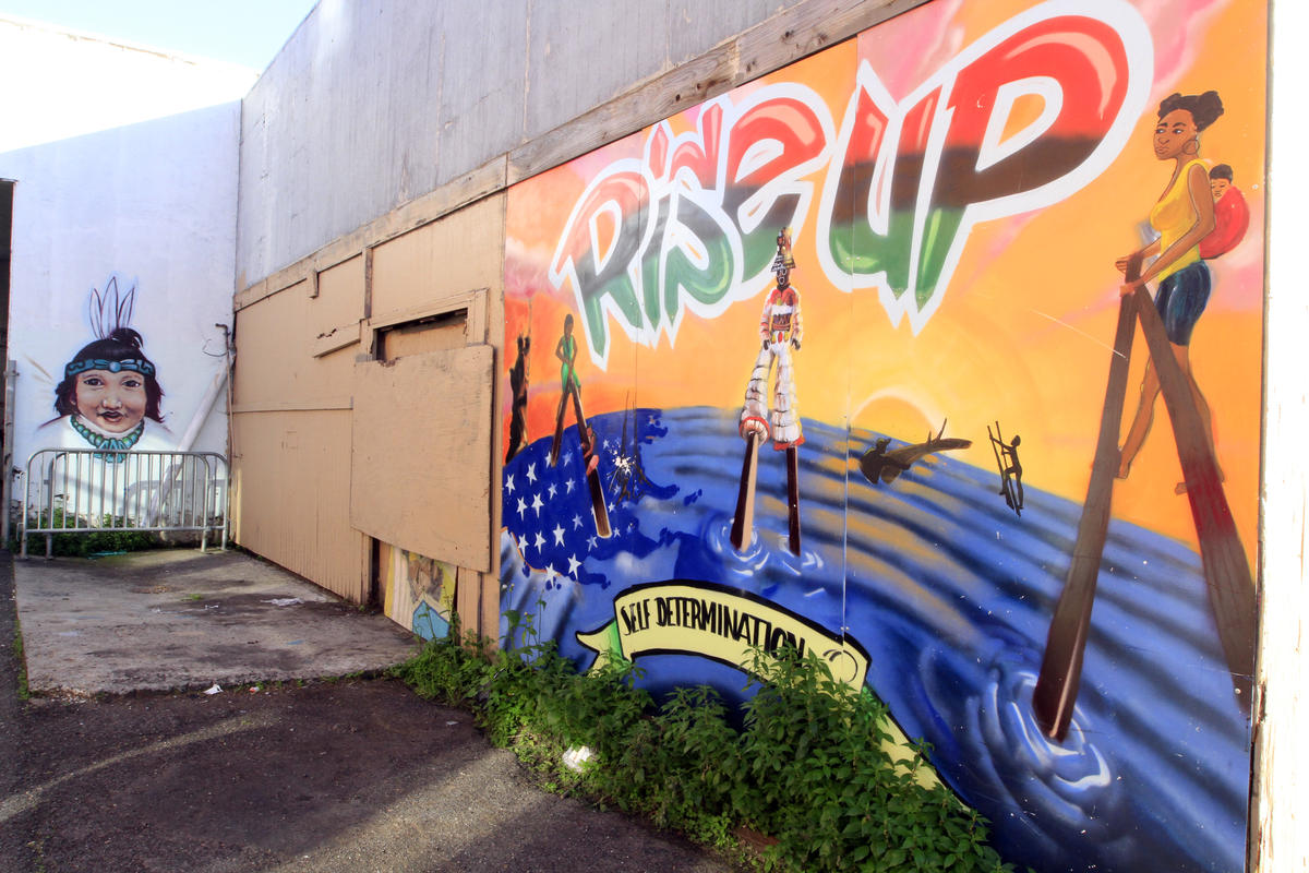 Cultural and political murals cover the walls surrounding the Eastside Arts Alliance on International Boulevard on Wednesday, March 16, 2016 in Oakland, Calif. Students and professional artists team up to create the murals.(Laura A. Oda/Bay Area News Group)