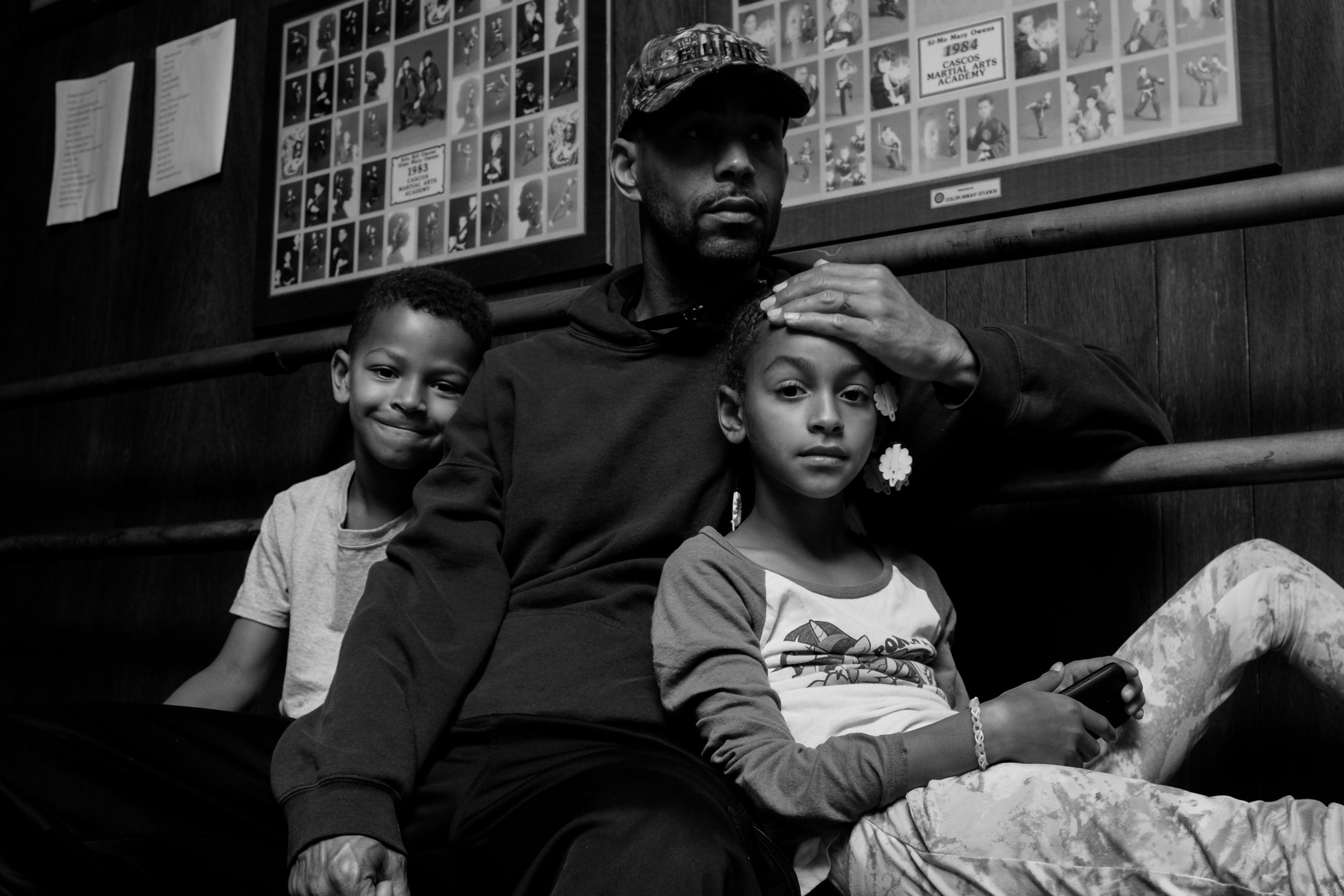 A black and white image of a Black dad with two children