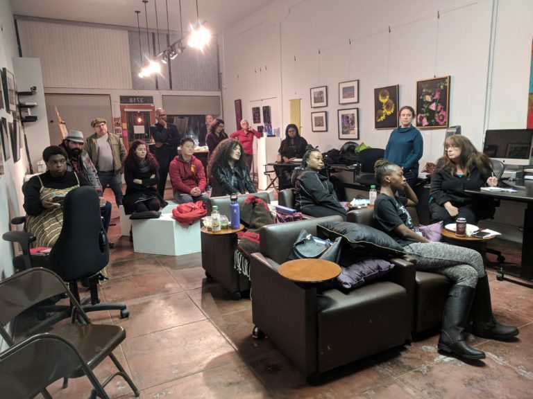 An image of a diverse group of people inside a meeting space