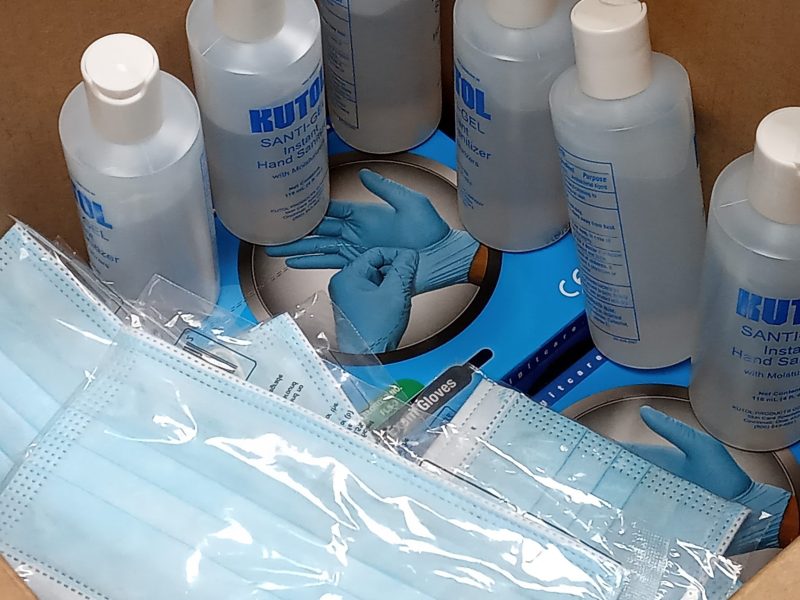 A photo of surgical masks, hand sanitizer, and gloves
