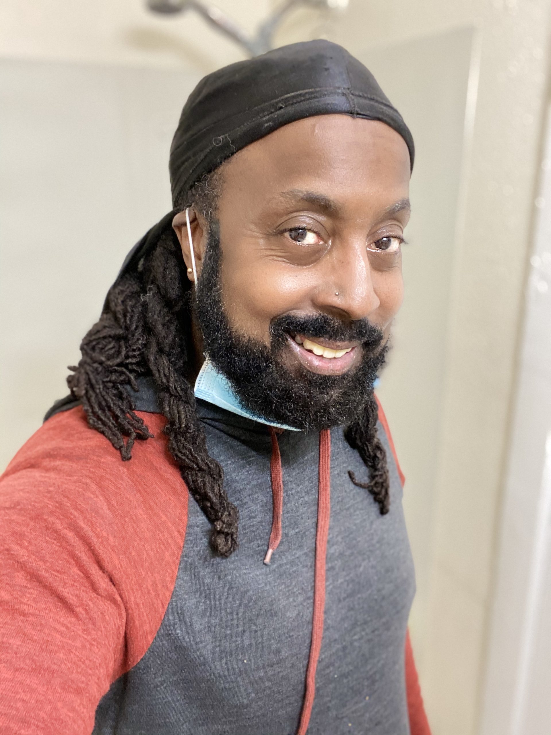 An African American man smiles at the camera.