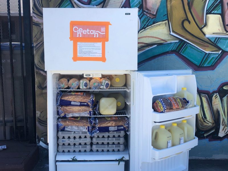 An open small refrigerator door with "Cheetah" in orange logo. The fridge has bread, juice, and eggs.