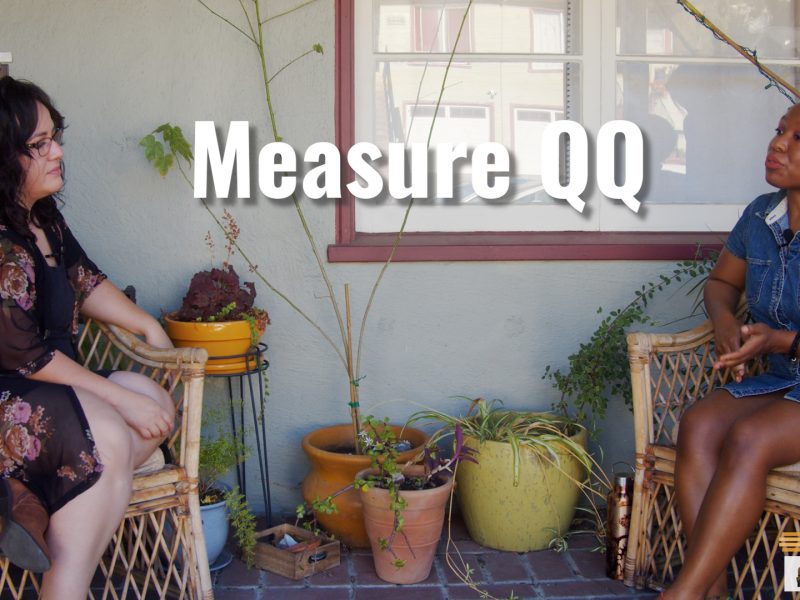 A Latina woman sits on the porch with an African American woman with short hair.