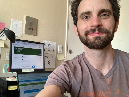 A man takes selfie in front of a computer