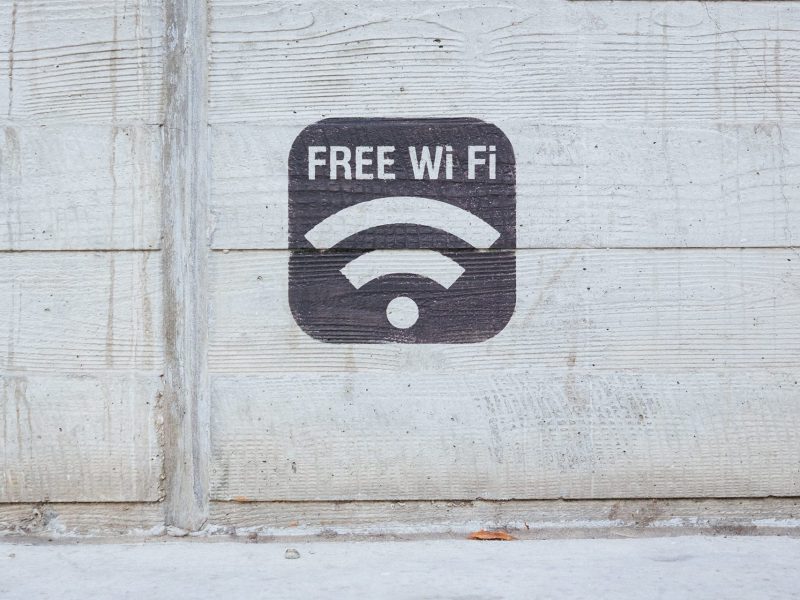 a stencil painting that says "free wifi" against concrete backdrop.
