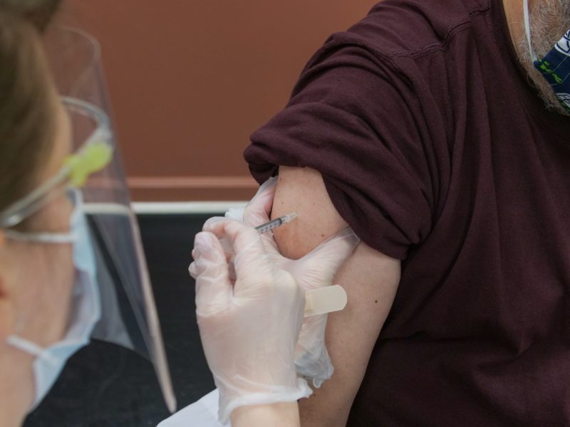 close up image of a shot going into a man's arm.