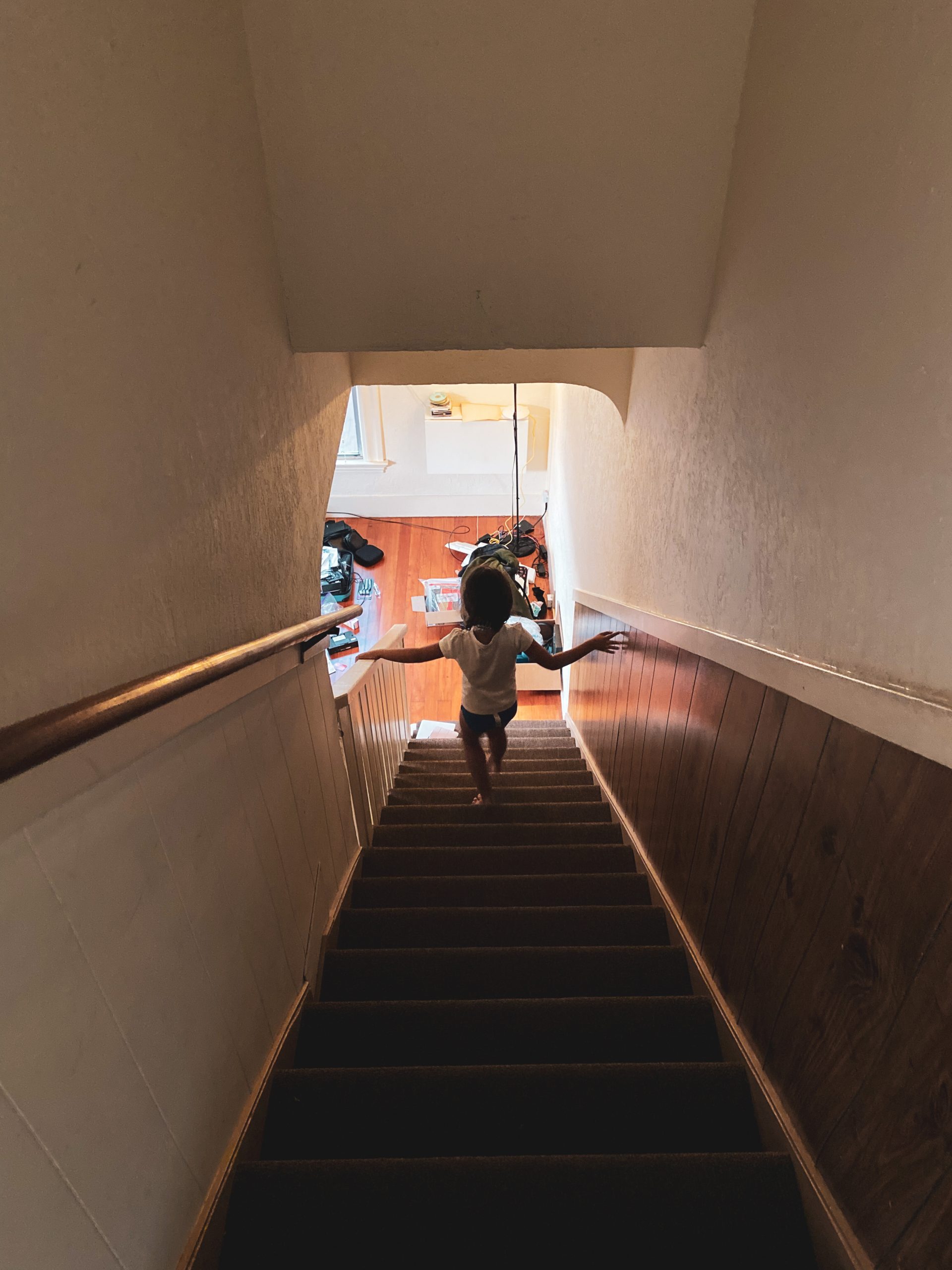 a young girl walks down the steps from an apartment