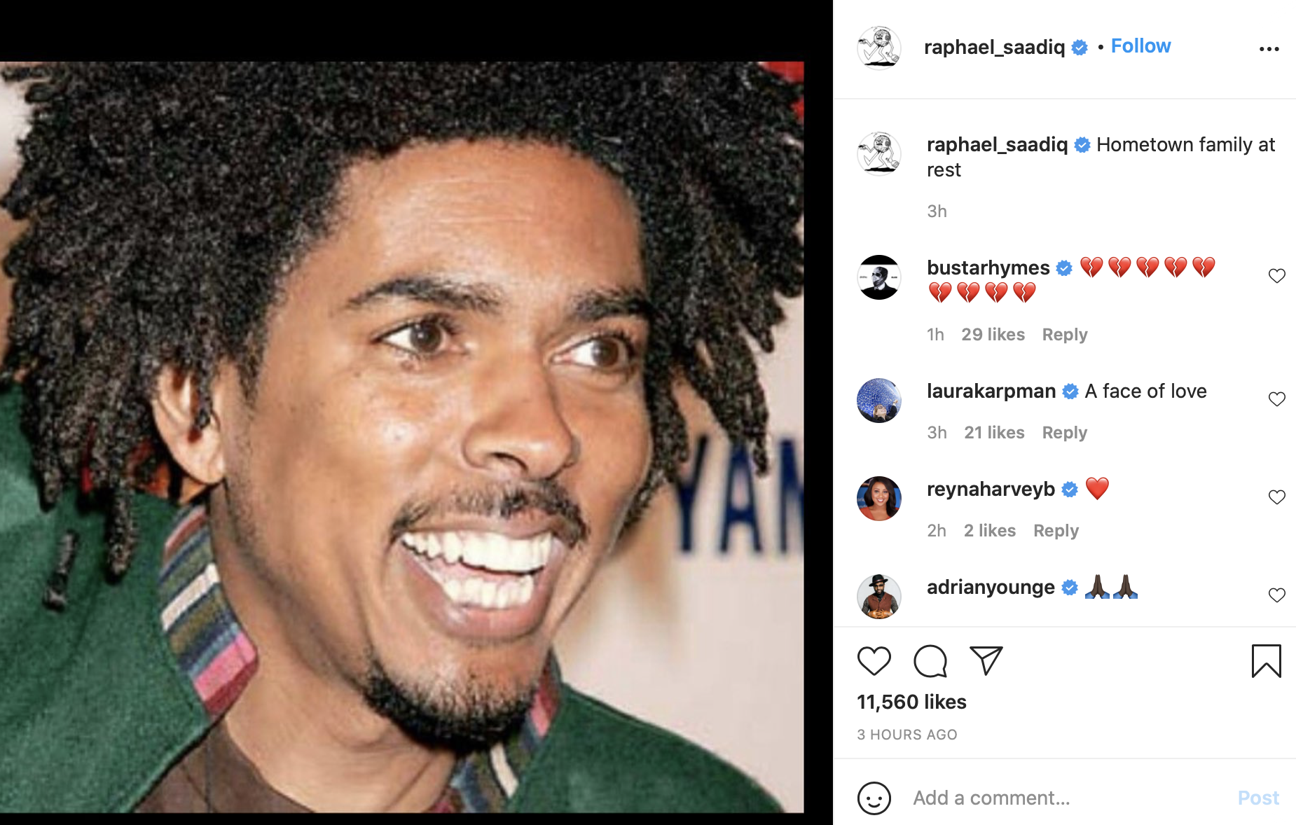 a close up of a man with an Afro, looking off and smiling/grinning