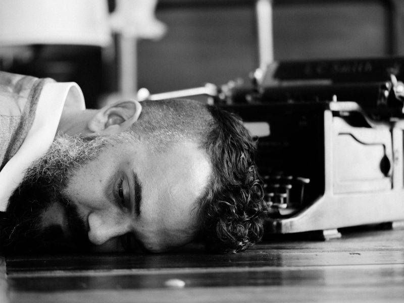 a man puts his head down on the ground in a black and white photo