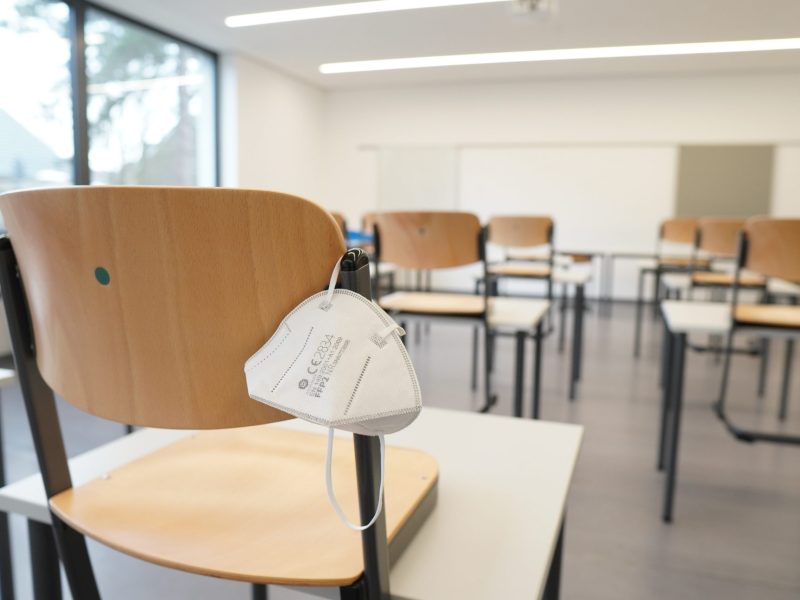 empty classroom and desks with one n95 mask