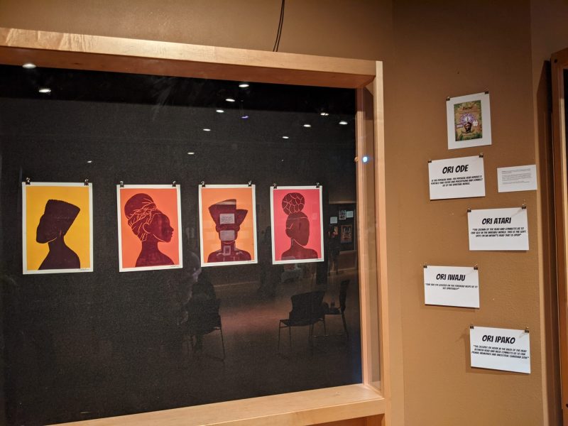 An art exhibit with silhouettes of African American women on display.