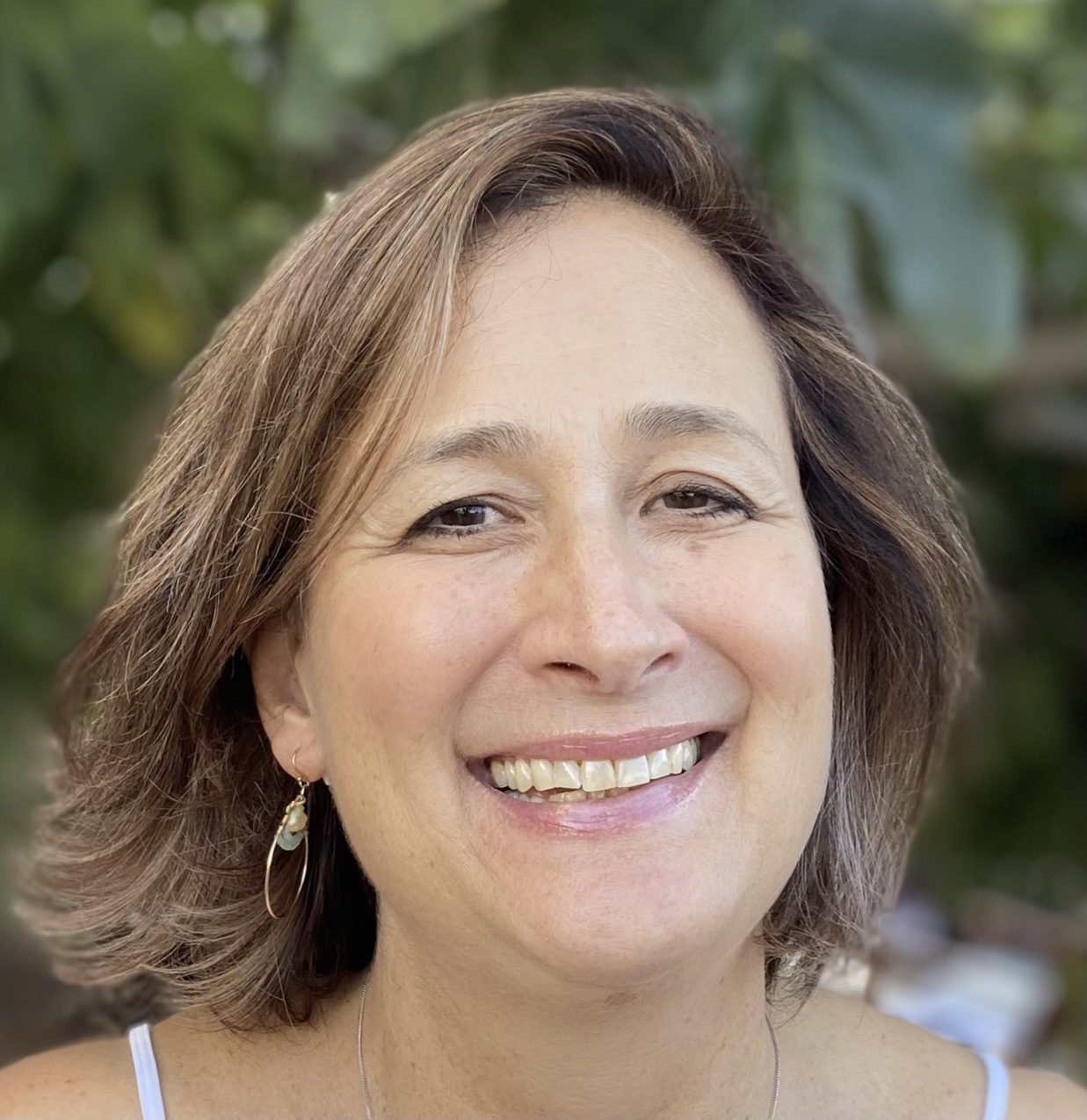 A woman with short brown hair smiles at camera