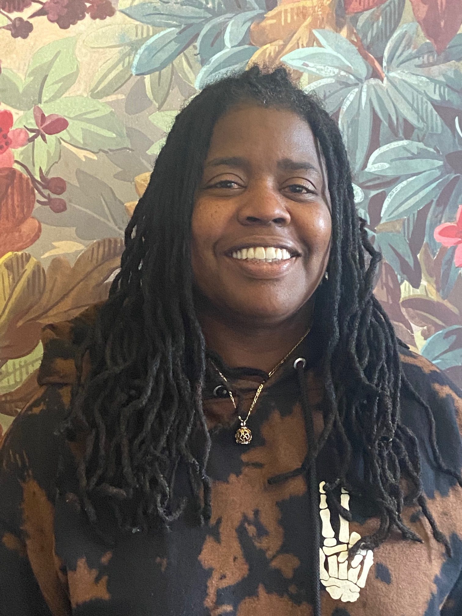 An African American woman with long hair smiles for the camera