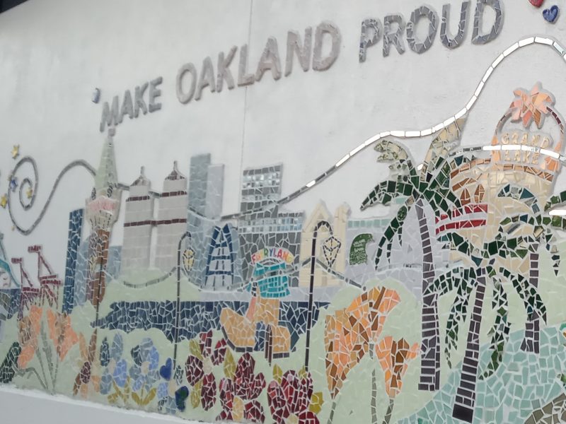 a wall outside a school that says "make oakland proud"