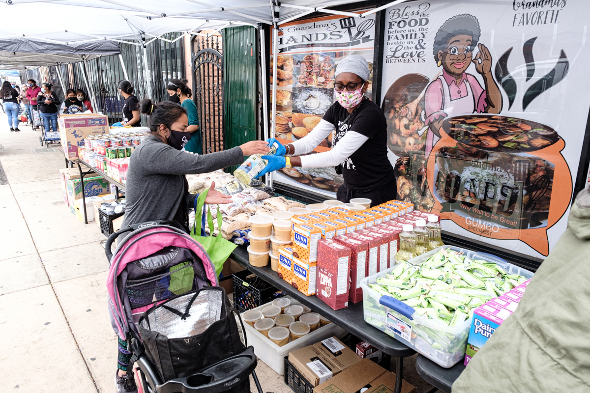 a person hands out food to someone from an outdoor table
