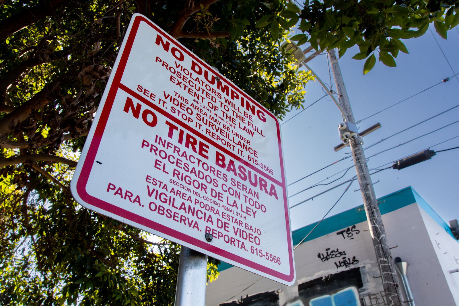A sign that says "no trash" and also in Spanish, no basura in red letters against white background 