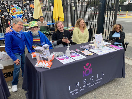 a group of disabled and possibly non disabled folks stand behind a table that says "CIL"