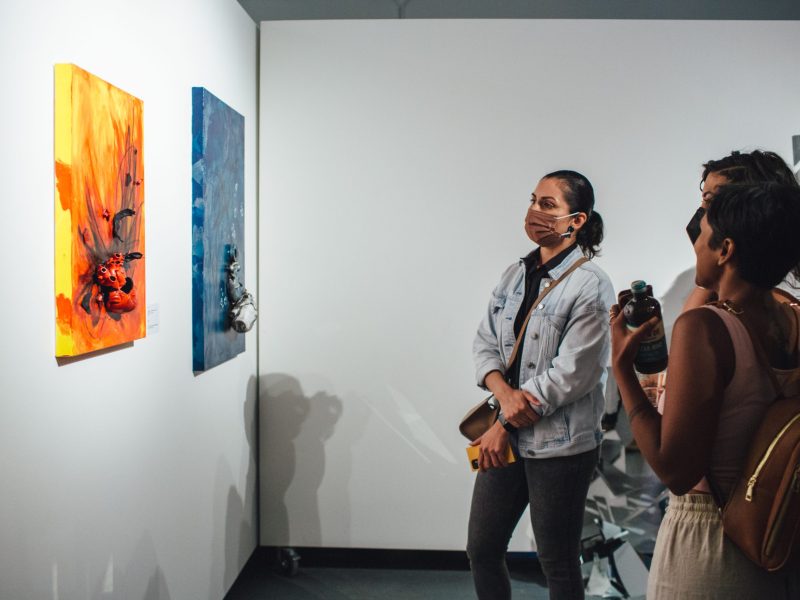 visitors at an art installation looks at a 3D artwork on the wall