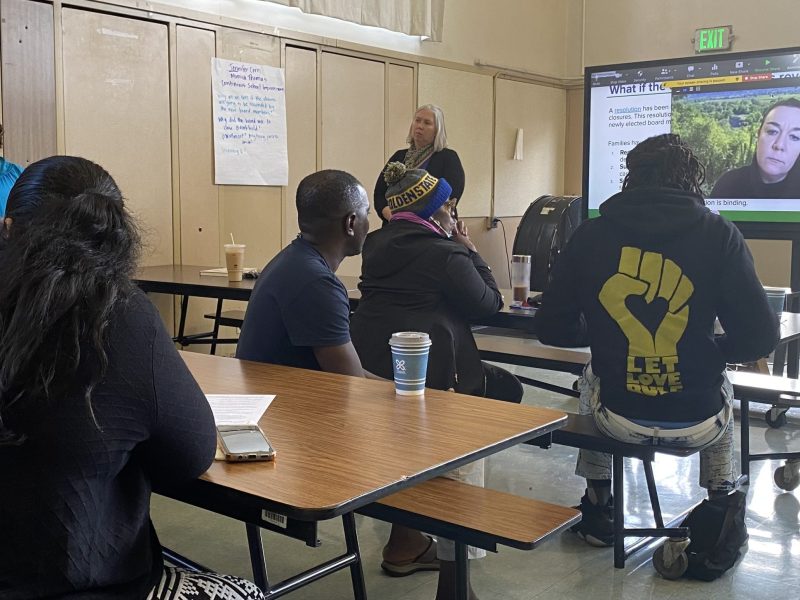 A group of parents at an elementary school listen to OUSD and someone on Zoom.