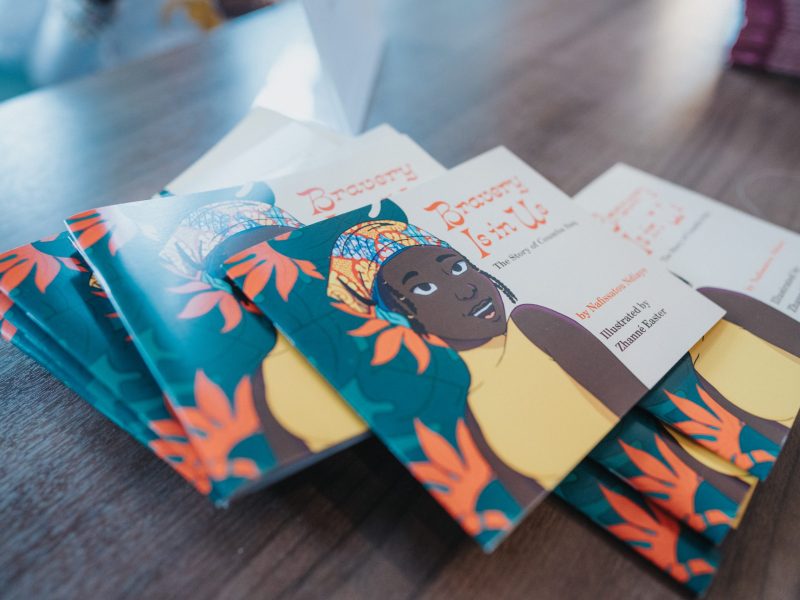 A group of books with an African woman on the cover are on a brightly lit table