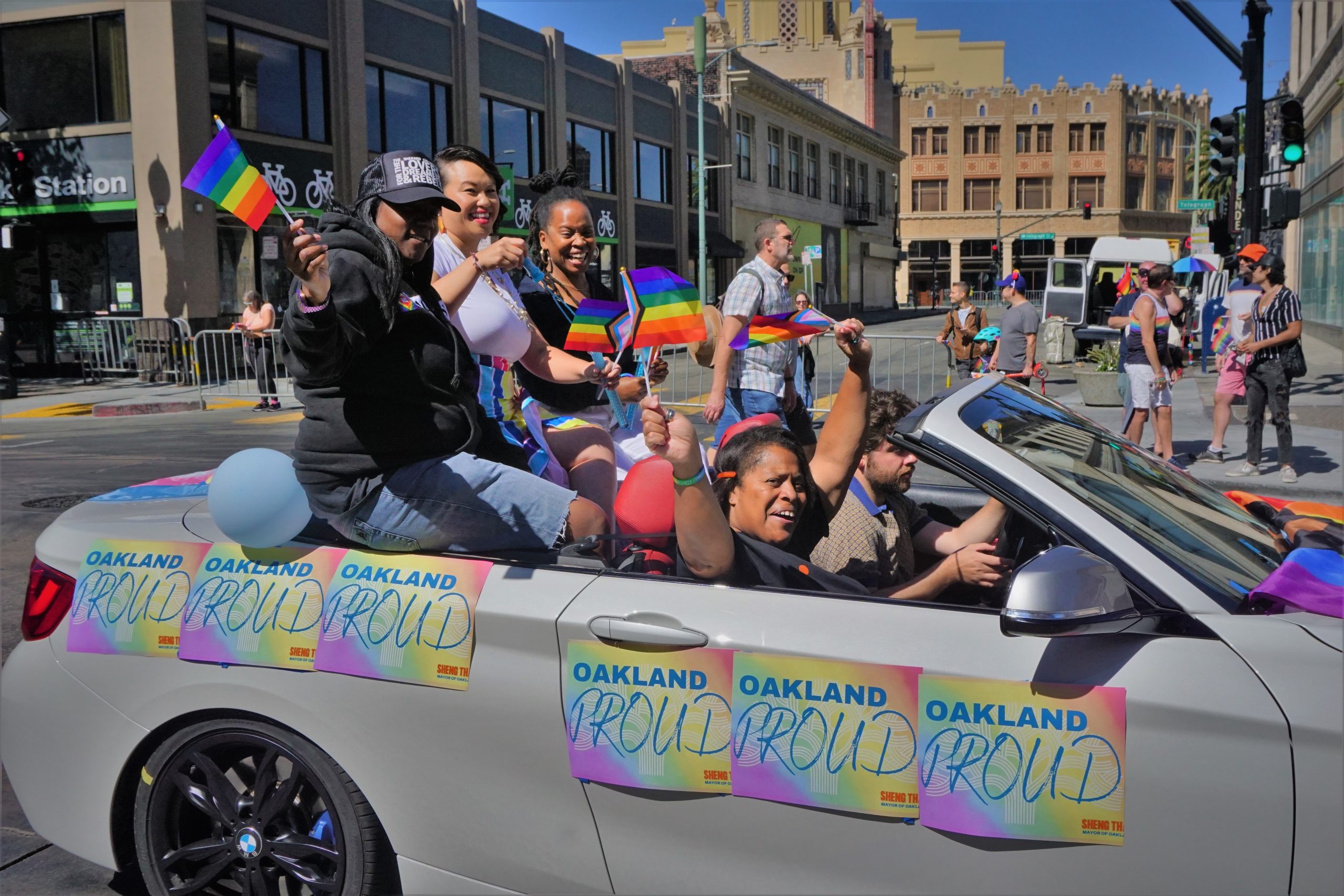 a car full of diverse women and politicians in a pride parade