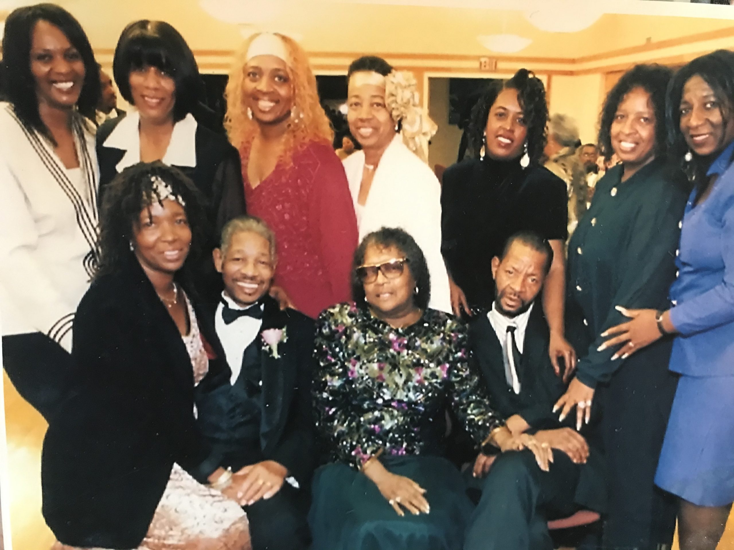 A Black family pose for a photo with their siblings and mother