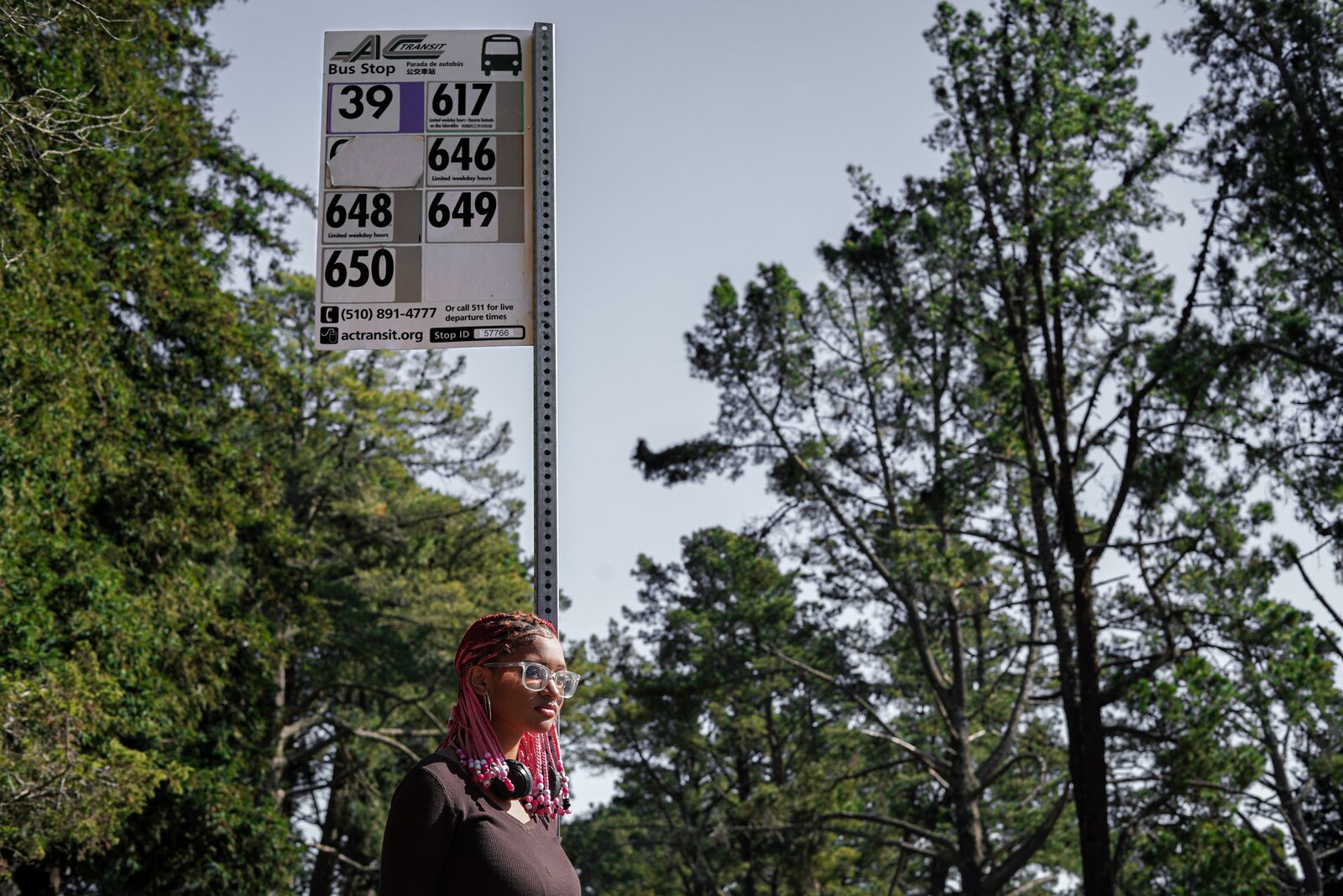 An African American girl waits at a bus stop