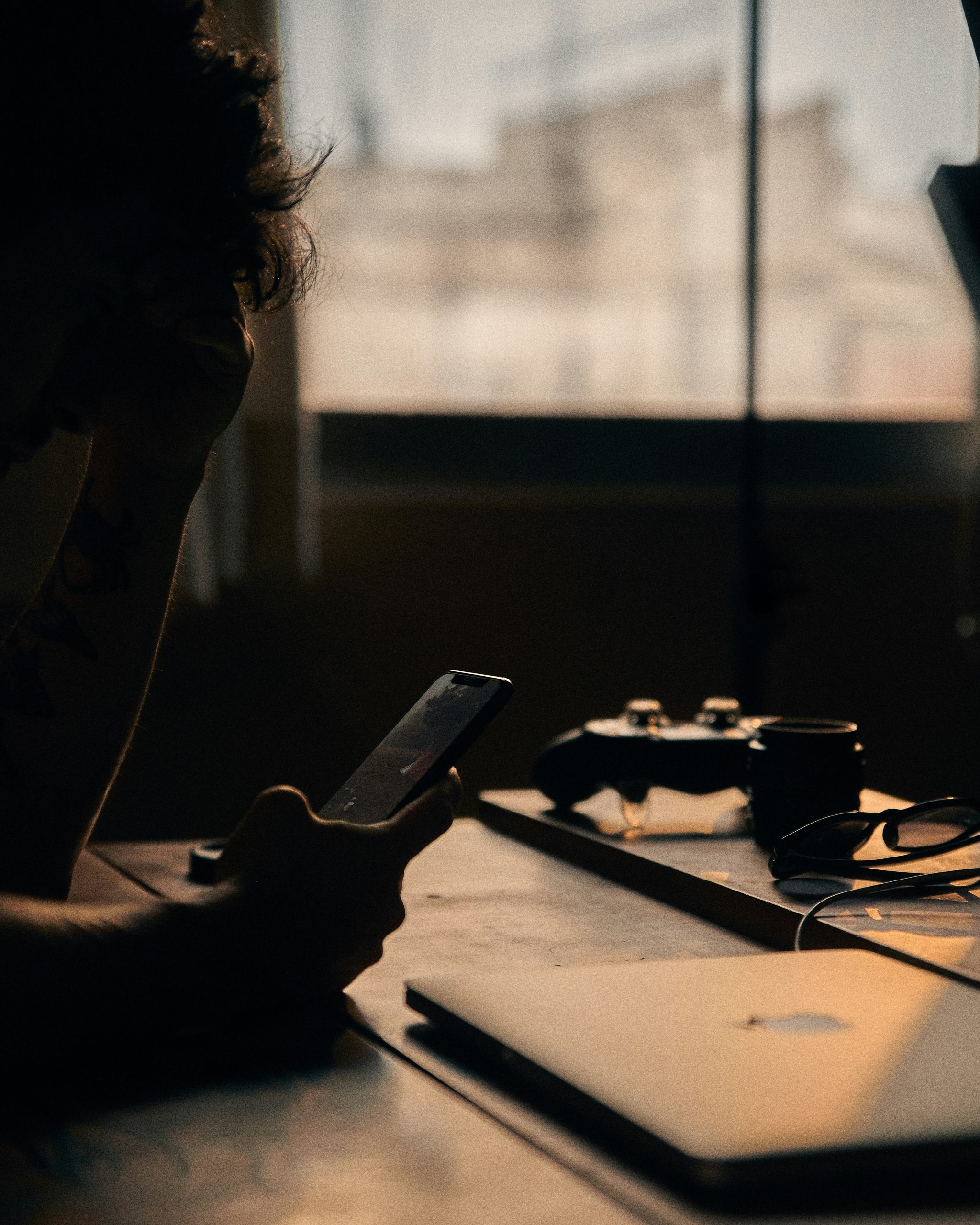 dark image of hand holding a phone in social isolation