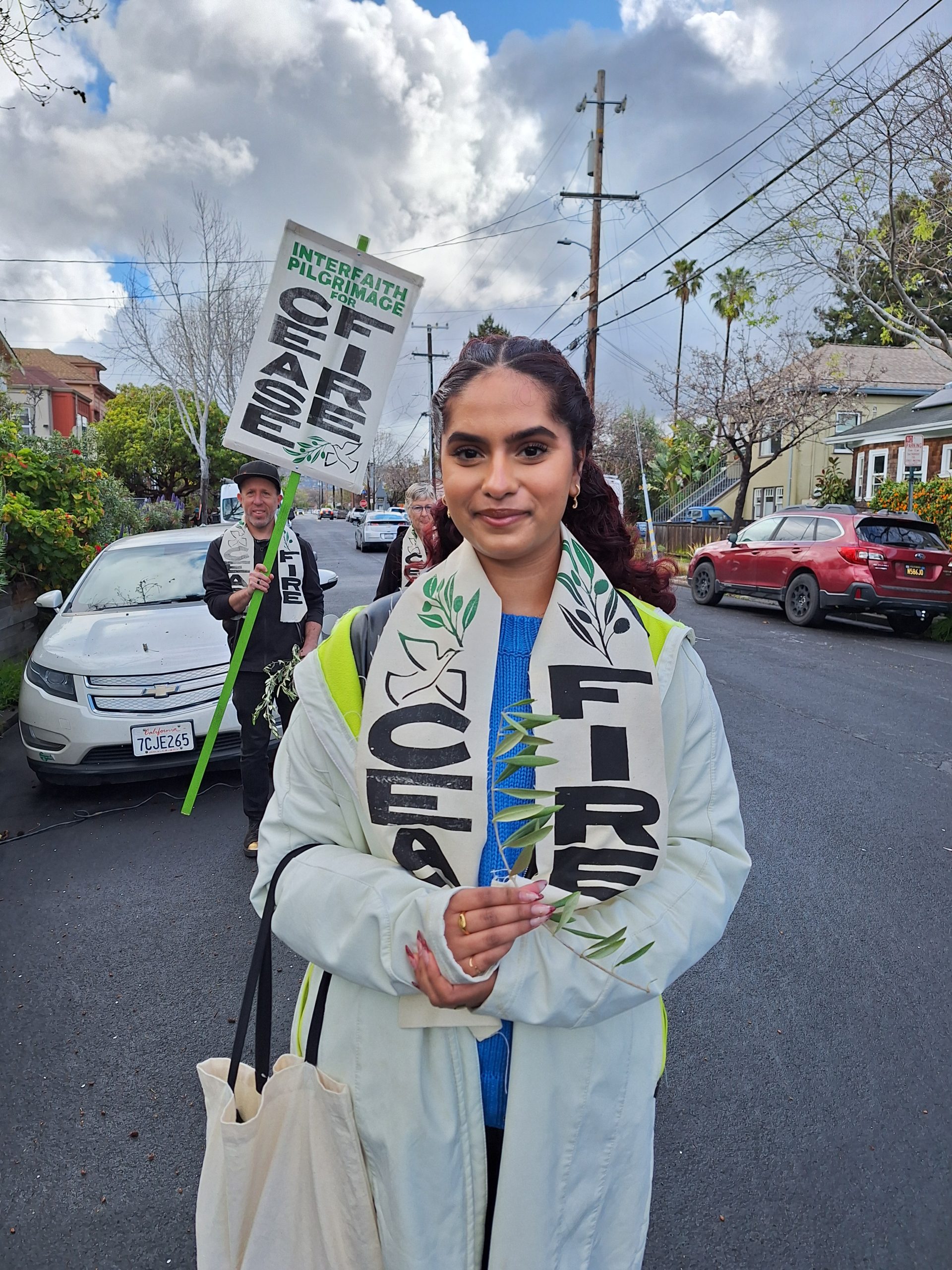 A young woman smiles for camera while wearing a ceasefire white scarf