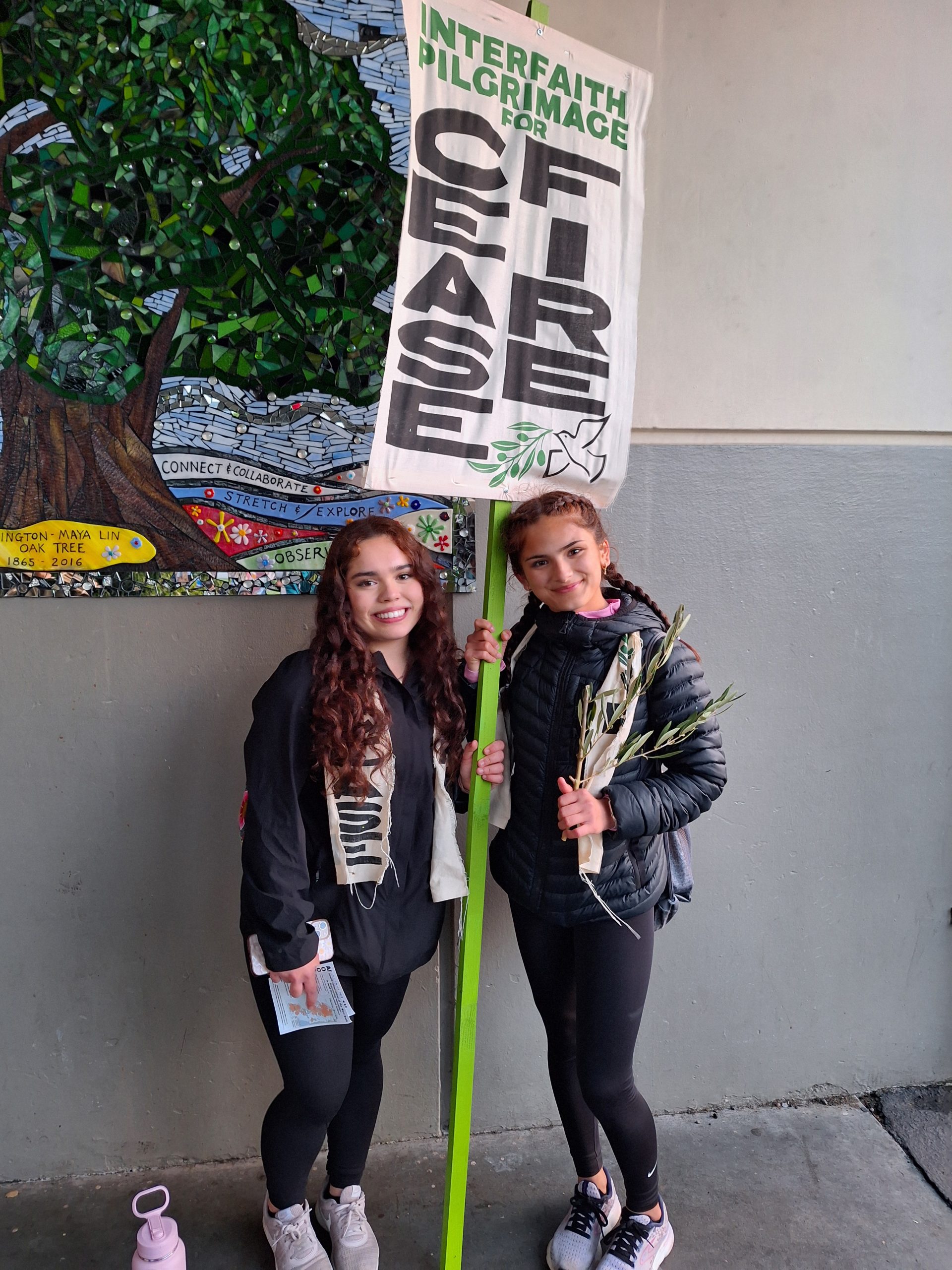 Two young women hold a sign that says ceasefire