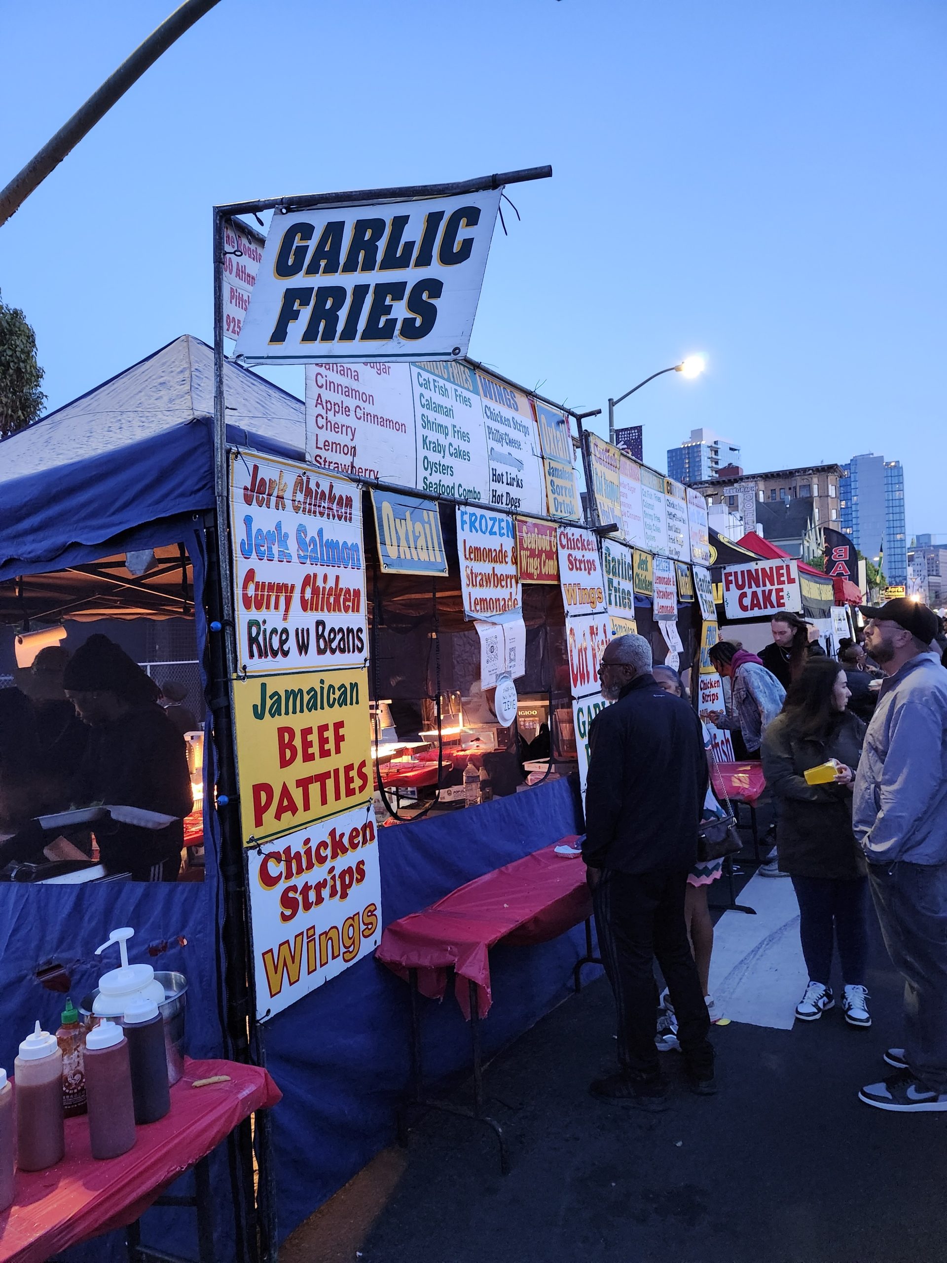 An outdoor booth selling garlic fries and other food