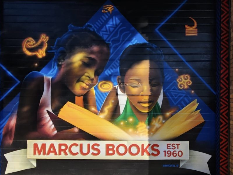 a colorful mural depicting African Americans and the words "Marcus Books est. 1960" in red letters