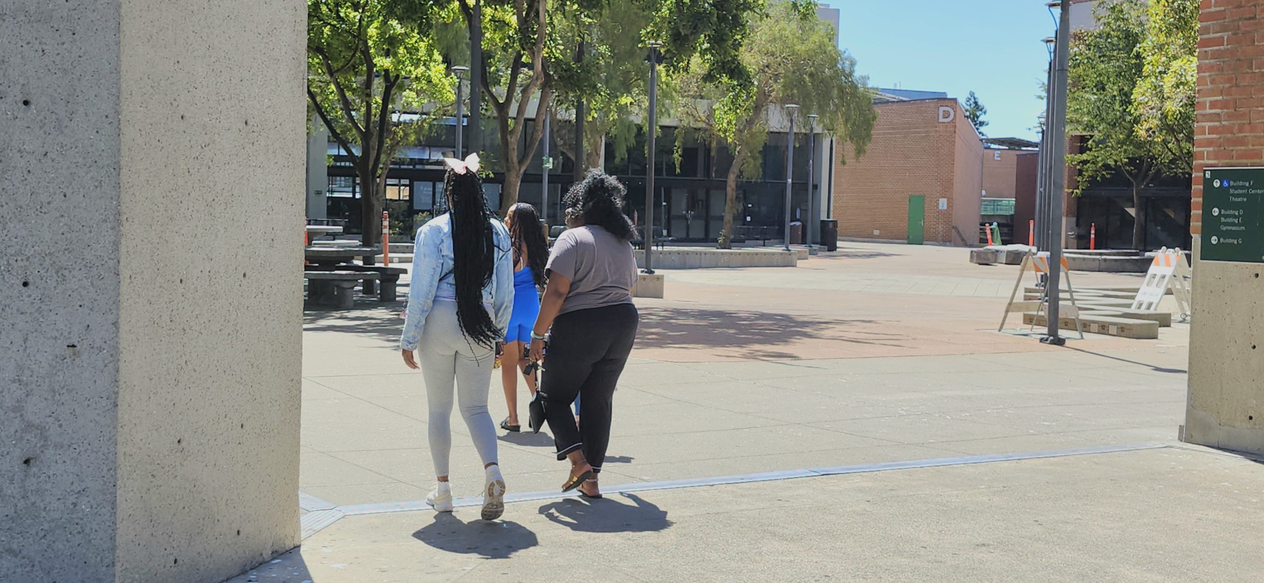 students walk on campus on a sunny day